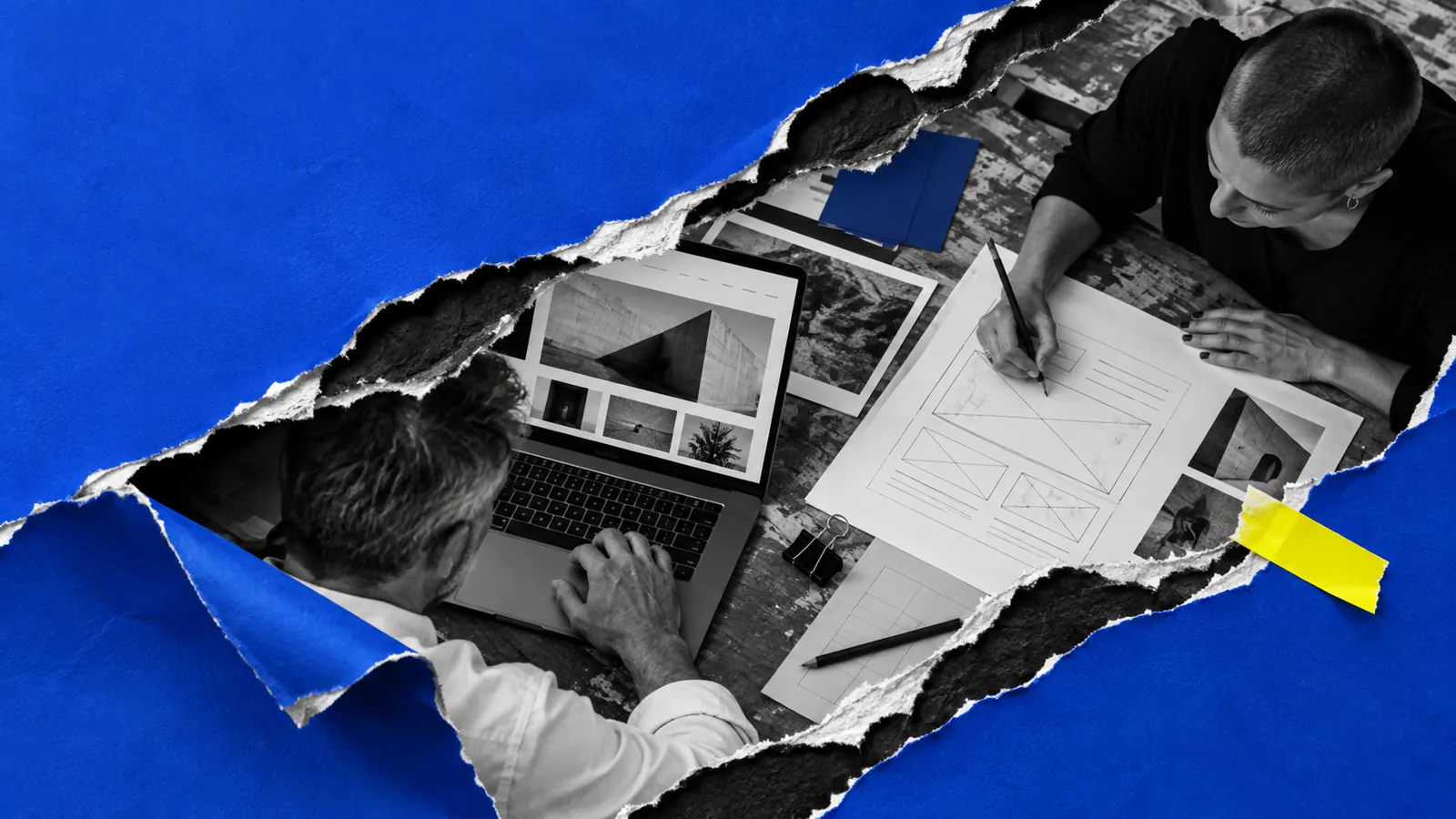 Zwei Menschen arbeiten an einem Entwurf: eine Hand skizziert eine Seite mit Bleistift, daneben ein Laptop